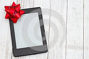 An ereader with gift bow on a old weathered table