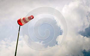 Erect red and white windsock on a pole