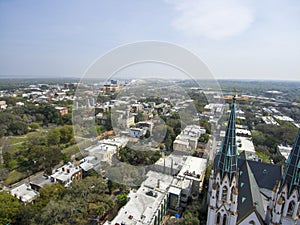 erial shot of the office buildings, apartments and shops in the city skyline surrounded by a river, lush green trees, roads and photo