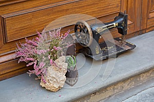 Erica carnea flower next to antique sewing machine decorating ho photo