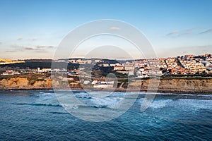 Ericeira drone aerial view on the coast of Portugal with surfers on the sea at sunset