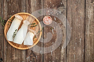 eringi mushrooms on a wooden background. Natural plant, banner, menu, recipe place for text, top view