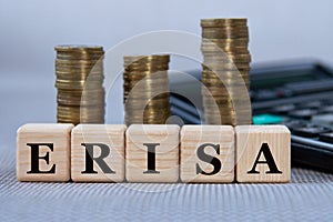 ERISA - acronym on wooden cubes on the background of coins and calculator