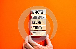 ERISA symbol. Concept words ERISA employee retirement income security act on wooden block. Beautiful orange table orange