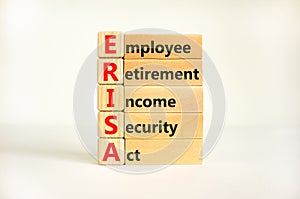 ERISA symbol. Concept words ERISA employee retirement income security act on wooden block. Beautiful white table white background