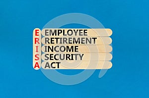 ERISA symbol. Concept words ERISA employee retirement income security act on wooden stick. Beautiful blue table blue background.