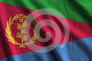 Eritrea flag with big folds waving close up under the studio light indoors. The official symbols and colors in banner