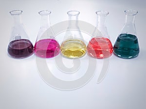 The Erlenmeyer or Conical flask in line on bench laboratory, with colorful solvent from titration experiment, acidity, alkalinity.