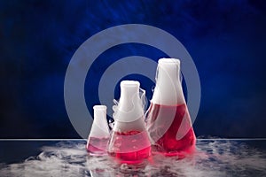 Erlenmeyer flask with red liquid on the table photo