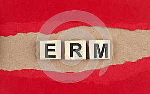 ERM word on wooden cubes on red torn paper , financial concept background