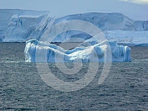 Eroded blue iceberg floats in the Lemaire Channel Antarctica