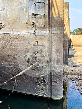 Eroded Concrete Surface of a Dam Structure with Accumulated Tree and Grass Debris