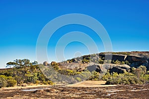 Eroded granite rocks, boulders and stunted outback vegetation, Western Australia