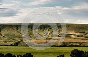 Eroded hill structure, agricultural field in steppe.