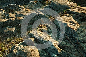 Eroded rocks with green grass on sunset