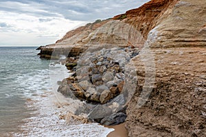 The eroding cliffs at Port Noarlunga and the protective rocks pl