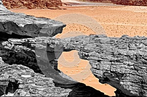 Erosion formed stone bridge, black and white alienated with colored background and abstract effect, in the nature reserve of Wadi