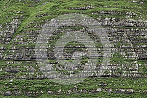 Erosion lines of stratified sedimentary rocks in steep mountainside