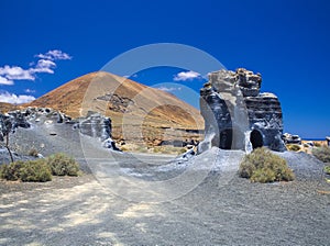 Erosion weathering blue rock formations Plano de El Mojon against the background of a volcanic cone, blue sky photo