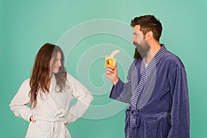 Erotic games for couple. Couple in love blue background. Sensual couple. Sexy woman look at bearded man eating banana