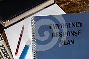 ERP as an emergency response procedure, the text is written on a blue book lying on the office Desk