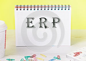 ERP enterprise resource planning word written on a notebook with paper clips , business concept