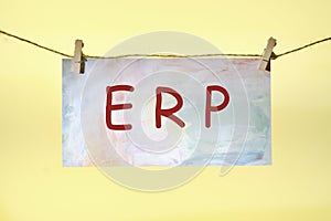 ERP text on colored paper hanging on a rope with clothespins. concept for enterprise resource planning with icon of inventory,