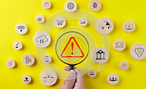 Error notification concept. Magnifying glass focusing red triangle caution warning sign and wood block with business technology