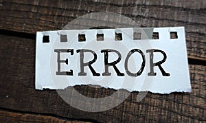 ERROR word on a small sheet of paper and a wooden table