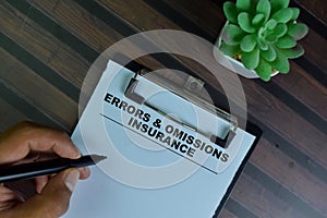 Errors & Omissions Insurance write on a paperwork  on Wooden Table