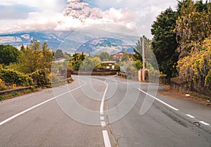 Eruption of the Etna volcano on the horizon of the lonely road on Sicily