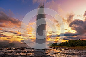 Eruption of Strokkur geyser in Iceland at sunset