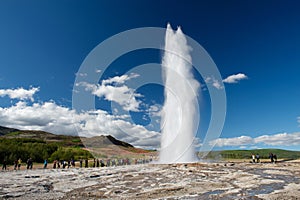 Impresionante erupción de los mayores activos de geysir, Strokkur, con turistas que esperaban alrededor, círculo de Oro, Islandia.