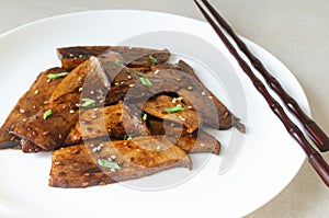 Eryngii mushroom fried with sesame and green onion on a white plate. Gochujang King Oyster Mushrooms. photo