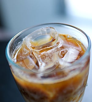 Es Teh. iced tea is a fresh drink made from tea, water, sugar, and ice cubes. iced tea in a clear glass on a brown