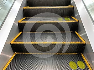 Escalator with color mask on stair for social distancing concept.