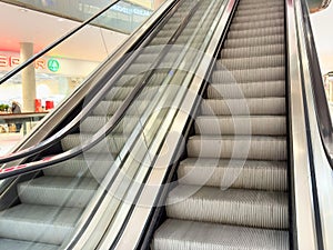 Escalators in modern shopping mall interior with glass railings