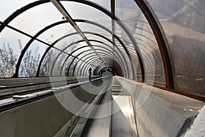 The escalators in a transparent tunnel to see the outside