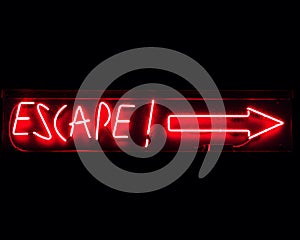 Escape neon sign in red with arrow pointing right on black background