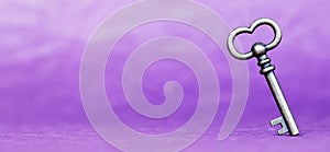 Escape room concept. Vintage key on purple background, web banner photo