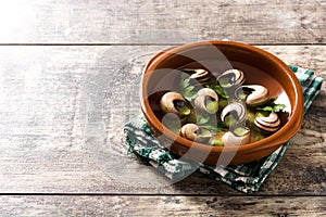 Escargots de Bourgogne in brown bowl on wood