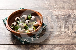 Escargots de Bourgogne in brown bowl on wood