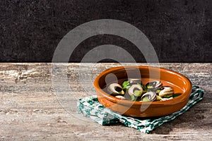 Escargots de Bourgogne in brown bowl on wood