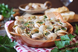 Escargots, traditional French cuisine: snails sauce Burgundy and baguette