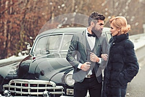 Escort of girl by security. Couple in love on romantic date. Bearded man and sexy woman in fur coat. Retro collection