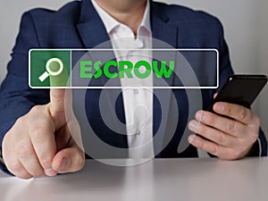 ESCROW text in search line. Loan officer looking for something at smartphone. ESCROW concept