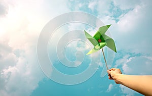 ESG and Clean Energy Concept. Hand Raise up a Wind Turbine Paper into the Sky. Decrease Carbon and Produce a Green Power. World photo