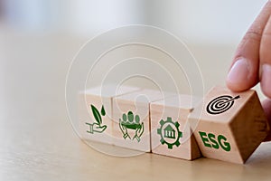 ESG concept of environmental, social and governance. Sustainable corporation development. Hand flips wooden cubes with target sett