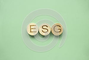 ESG concept of environmental, social and governance. Wooden alphabet with letter E, S and G on a green background