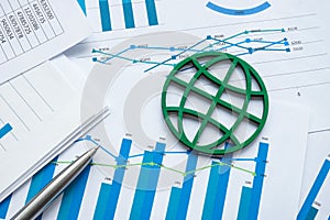 ESG concept. The green symbol of the globe lies on financial papers. photo